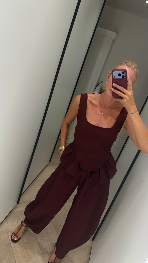 Burgundy peplum top and wide-leg trouser set close-up