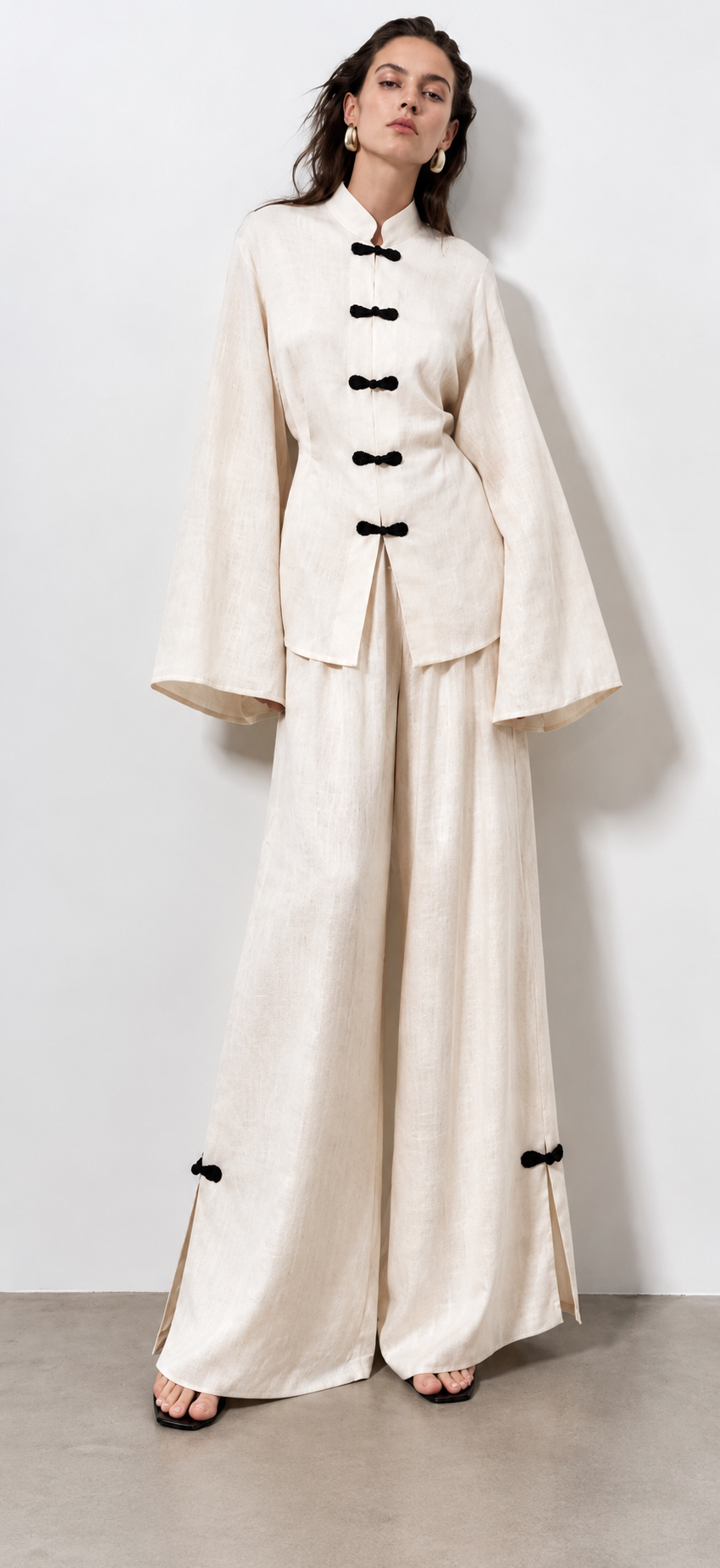 White linen top and wide-leg trousers with black bow fastenings